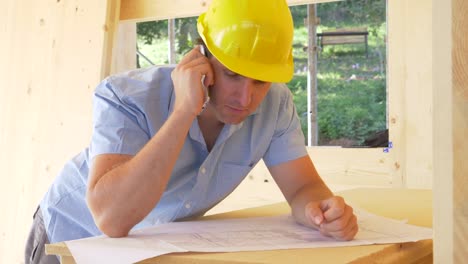 CLOSE-UP:-Architect-is-satisfied-as-he-talks-on-the-phone-about-the-floor-plans.