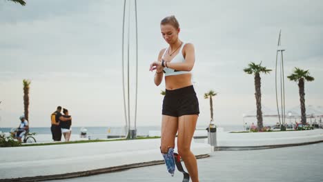 Behinderte-Läuferin,-die-ihren-Aktivitätsstatus-auf-der-Smartwatch-während-des-Trainings-überprüft