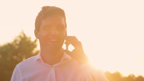 CLOSE-UP:-Man-cheerfully-talks-on-the-phone-on-sunny-evening-after-good-meeting.