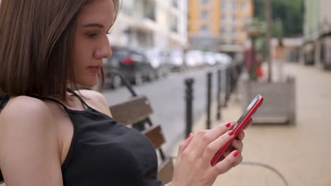 Cute-girl-use-red-smartphone-outdoor