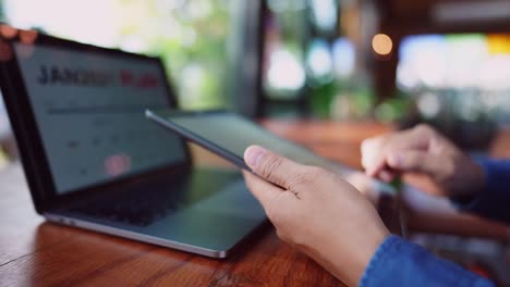 Un-joven-hombre-de-negocios-que-lleva-una-máscara-quirúrgica-está-haciendo-una-videoconferencia-con-los-clientes-a-través-de-una-tableta-que-está-conectada-a-Internet