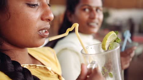 Dos-mujeres-que-beben-bebidas-usando-tecnología-en-café