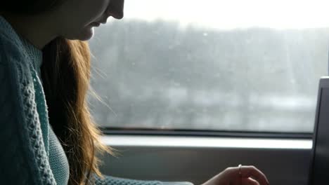 Female-hands-typing-on-keyboard-of-laptop-in-train.-Woman-chatting-with-friends-during-traveling-on-railway.-Young-girl-using-notebook.-Arm-print-a-message.-Close-up