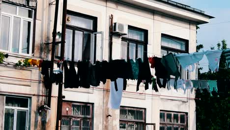 Large-number-of-washed-laundry-hangs-on-a-rope-and-dries-on-the-street-near-the-house