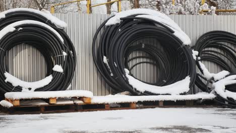 Materiales-de-construcción-para-la-venta-almacenados-en-estantes-de-metal-al-aire-libre-en-un-patio-de-almacén-junto-con-plataformas-de-madera-para-carga,-almacenaje-y-distribución