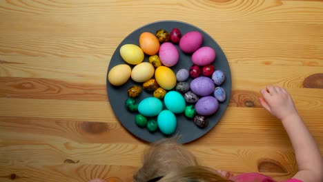 Timelapse-de-los-niños-las-manos-tomando-los-huevos-de-Pascua-multicolores-de-una-placa