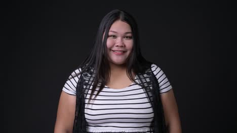 Beautiful-overweight-Asian-woman-against-black-background