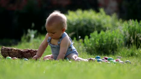 Niedlichen-Kind,-spielt-mit-kleinen-Häschen-und-Ostern-Eier-in-einen-blühenden-Garten,-Frühling.-Junge-mit-Kaninchen-spielen,-Ei-Jagd-für-Urlaub