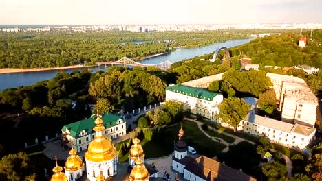 Schöne-goldene-Kiew-Ukraine-St.-Michael-goldenen-Kuppel-Kloster.-Ansicht-von-oben.-video-Luftaufnahmen.-Landschaft-Stadtansicht-"Dnipro"-und-Pishokhidnyy-Parkovyi-Brücke.