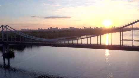 Aerial-shooting-pedestrian-bridge-of-Kiev-on-sunrise.-Summer-morning-in-Kiev-Dniepeer-river.-Ukraine.-European-city