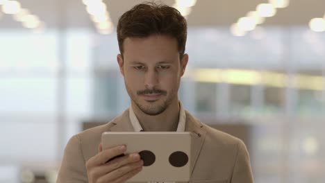 Caucasian-employee-working-online-and-mobile-at-train-station-with-digital-tablet