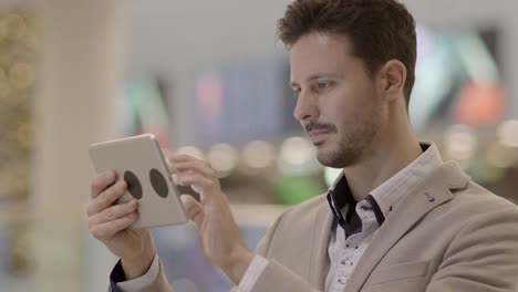 Caucasian-employee-working-online-and-mobile-at-train-station-with-digital-tablet