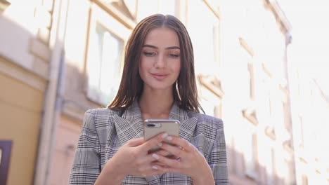 Beautiful-Woman-Using-Mobile-Phone-On-Street