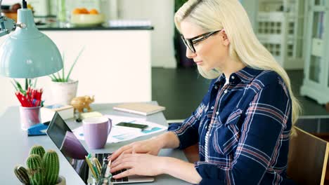 Attractive-Blond-Businesswoman-Typing-On-Laptop-In-Home-Office