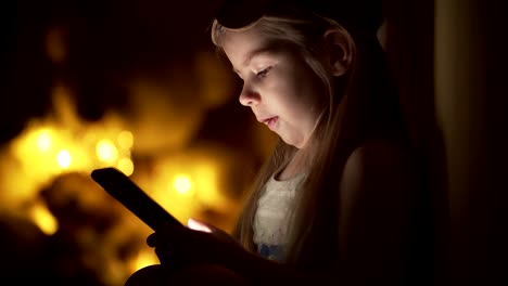 Niña-linda-en-la-noche-usa-smartphone-en-casa.-Escribir-mensaje-de-niña