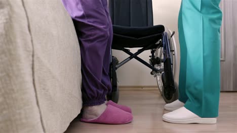 Nurse-helping-of-senior-disabled-woman-in-wheelchair