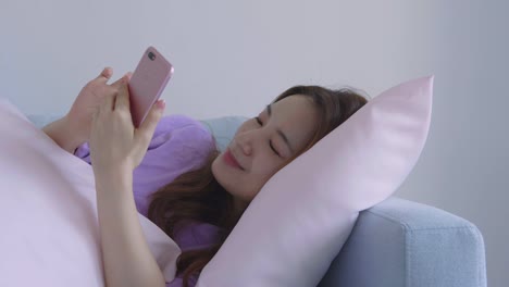 Asian-woman-using-cellphone-in-living-room