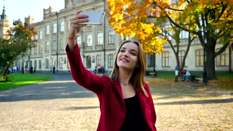 Junge-attraktive-Hündin-studend-macht-ein-Selfie-in-verschiedenen-Posen-vor-der-Universität-an-einem-sonnigen-Tag