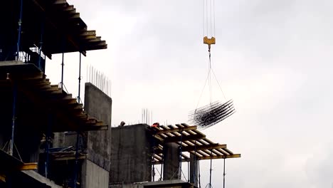 the-construction-crane-raises-the-weight-of-the-building-form-for-the-hardening-of-the-concrete