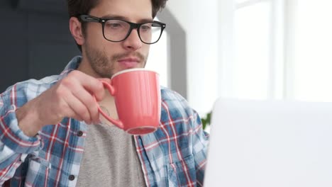 Mann-mit-Laptop-beim-Kaffeetrinken