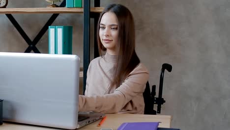 Behinderte-junge-Frau-arbeitet-mit-Laptop-im-Büro