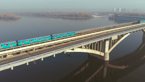 Zwei-U-Bahn-Züge-überqueren-einen-breiten-Fluss-über-die-Brücke