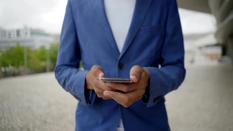 Tiro-recortado-de-hombre-afroamericano-usando-teléfono-inteligente.