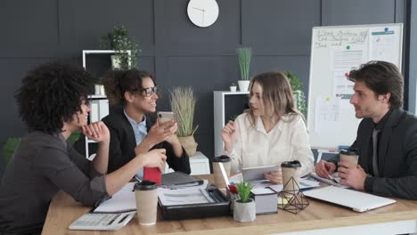 Business-Team-mit-Medieninhalten-auf-dem-Handy-im-Besprechungsraum