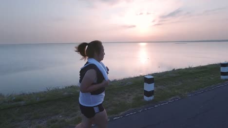 Asiatische-Frauen-joggen-in-der-Straße-am-frühen-Morgen-Sonnenlicht-am-Wasserspeicher-Pa-Sak-Jolasid-Dam.-Konzept-des-Gewichtsverlustes-mit-Bewegung-für-die-Gesundheit.-zeitlupe