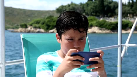 Junge-auf-dem-Boot-mit-dem-Smartphone