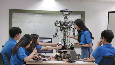 Junges-Elektronik-Ingenieur-Team,-das-beim-Bau-von-Robotern-in-der-Werkstatt-zusammenarbeitet.-Team-Ingenieur-starten-für-Roboter-Projekt-zusammen.-Menschen-mit-Technologie--oder-Innovationskonzept.