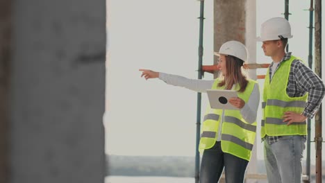 Engineers-or-architects-have-a-discussion-at-construction-site-looking-through-the-plan-of-construction.-contre-jour.-Engineers-or-architects-have-a-discussion.