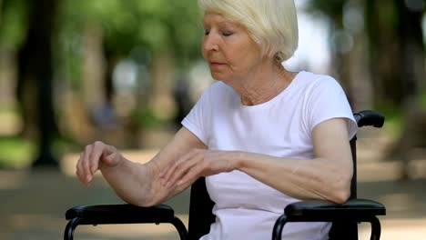 Mujer-madura-discapacitada-llorando-sentada-en-silla-de-ruedas-al-aire-libre,-soledad,-primer-plano