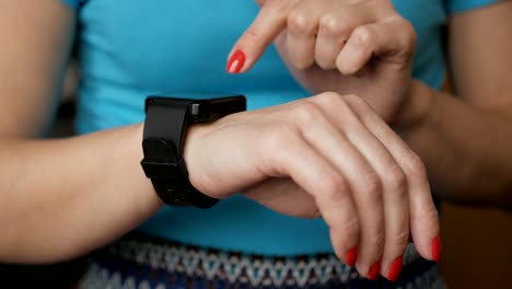 Mujer-usando-su-dispositivo-de-tecnología-portátil-de-pantalla-táctil-de-reloj-inteligente.-Mujer-usando-su-dispositivo-de-tecnología-portátil-de-pantalla-táctil-de-reloj-inteligente.-Chica-haciendo-gestos-en-un-reloj-inteligente-portátil,-de-cerca.