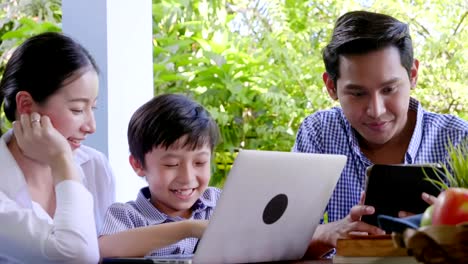 Asian-family-laughing-and-looking-in-digital-laptop-while-lying-home-Happy-holyday-time