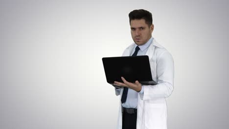 Doctor-showing-results-in-laptop-on-gradient-background