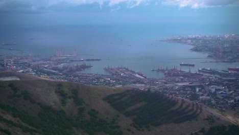 Footage-of-the-city-with-a-bay,-port,-buildings,-mountains.-Ariel-view-of-Novorossiysk.-Russia.