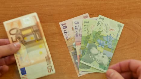 man-spread-out-Romanian-lei-on-desk-and-put-50-euros-aside