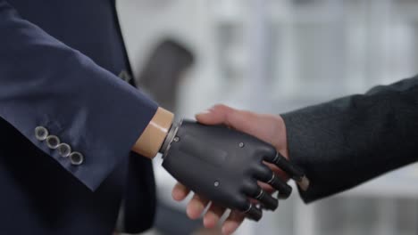 Handshake-von-Geschäftsmann-mit-Bionic-Hand-und-seinem-Kollegen