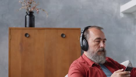 Retired-Man-Listening-to-Audio-Book-at-Home