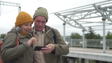 Personas-de-la-tercera-edad-que-utilizan-el-teléfono-en-la-estación-de-tren