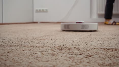 The-maid-wipes-the-dust-in-the-playroom,-robotic-vacuum-cleaner-cleans-the-carpet