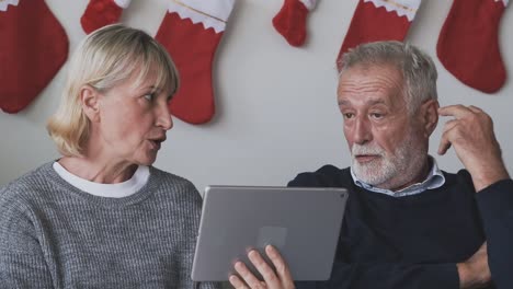 senior-elderly-Caucasian-old-man-and-woman-using-tablet-and-playing-internet-online-together