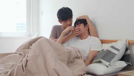 Handsome-Asian-gay-couple-talking-on-bed-at-home.-Young-Asian-LGBTQ+-guy-happy-relax-rest-together-spend-romantic-time-after-wake-up-in-bedroom-at-modern-house-in-the-morning-concept.