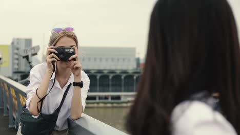 Asiatische-lesbische-Paare-genießen-Reisen-mit-Filmkamera-ein-Foto.-Zwei-schöne-junge-Frauen,-die-Spaß-in-der-Ferienzeit-haben.