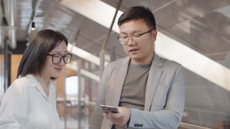 Two-Asian-Businesspeople-Using-Phone