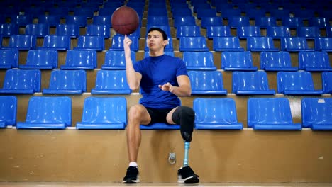 Ein-Männchen-mit-einem-künstlichen-Bein-spielt-mit-einem-Korbball-im-Sitzen