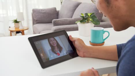 Back-view-:-Over-shoulder-view-of-asian-man-video-call-or-video-conference-with-girlfriend-feeling-happy.Asia-couple-greeting-via-tablet-online-connection-during-self-isolation-from-covidvirus.