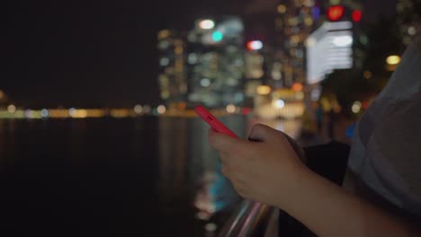 mujer-usando-el-teléfono-inteligente-en-la-noche-en-el-terraplén