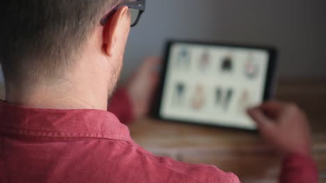 Unrecognizable-guy-buying-clothes-and-shoes-from-online-shop-using-tablet